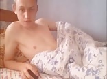 Uma linda loira nua na sua cama se masturbando