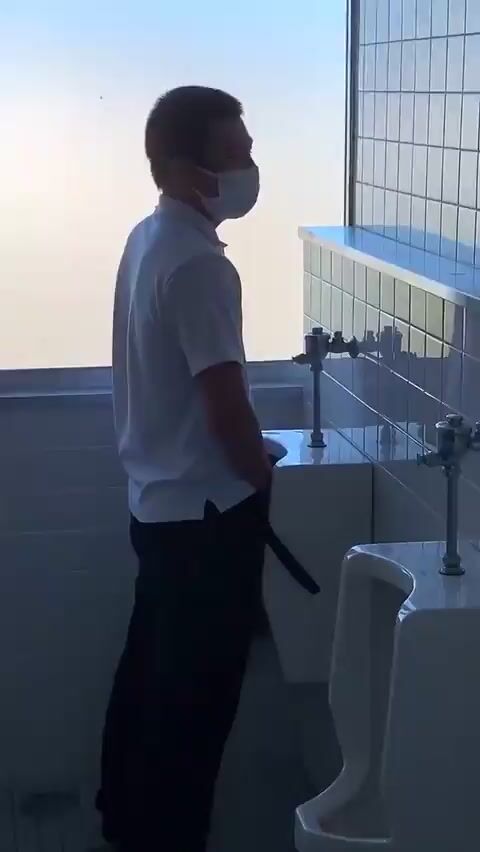 A male student is pissing in the toilet 7
