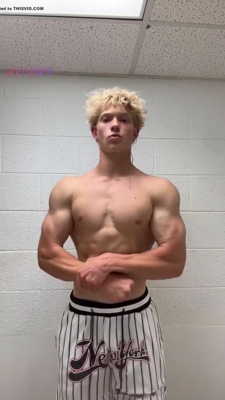 Blond muscle boy poses in locker room