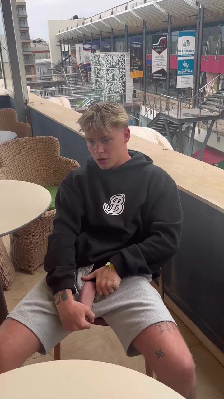 Blonder typ zeigt großen schwanz im straßencafé