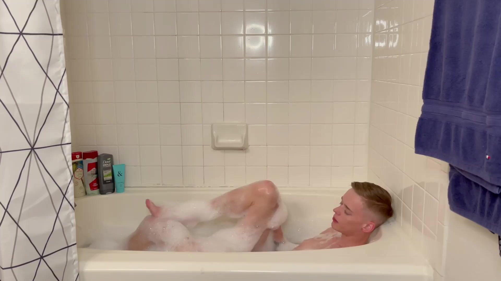 Bubble bath twink strokes his hard cock