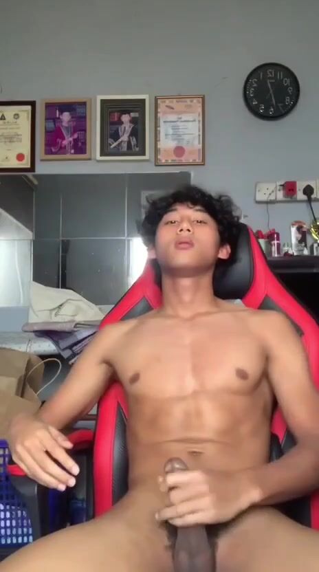 Asiatique musclé éjacule sur chaise rouge