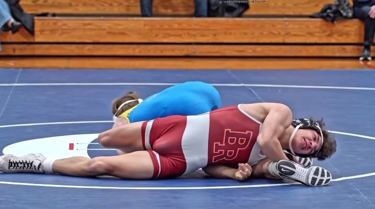 Bulging singlet teen flexes muscle