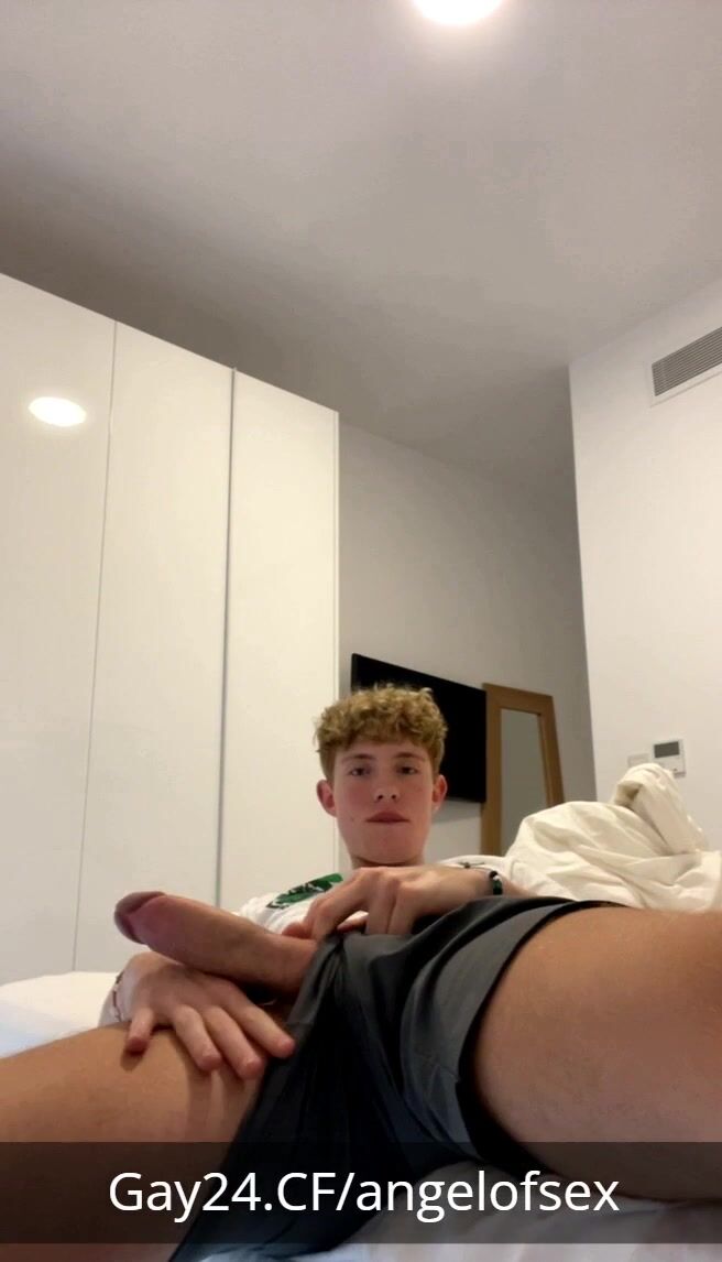 Blond curly hunk strokes big cock on bed