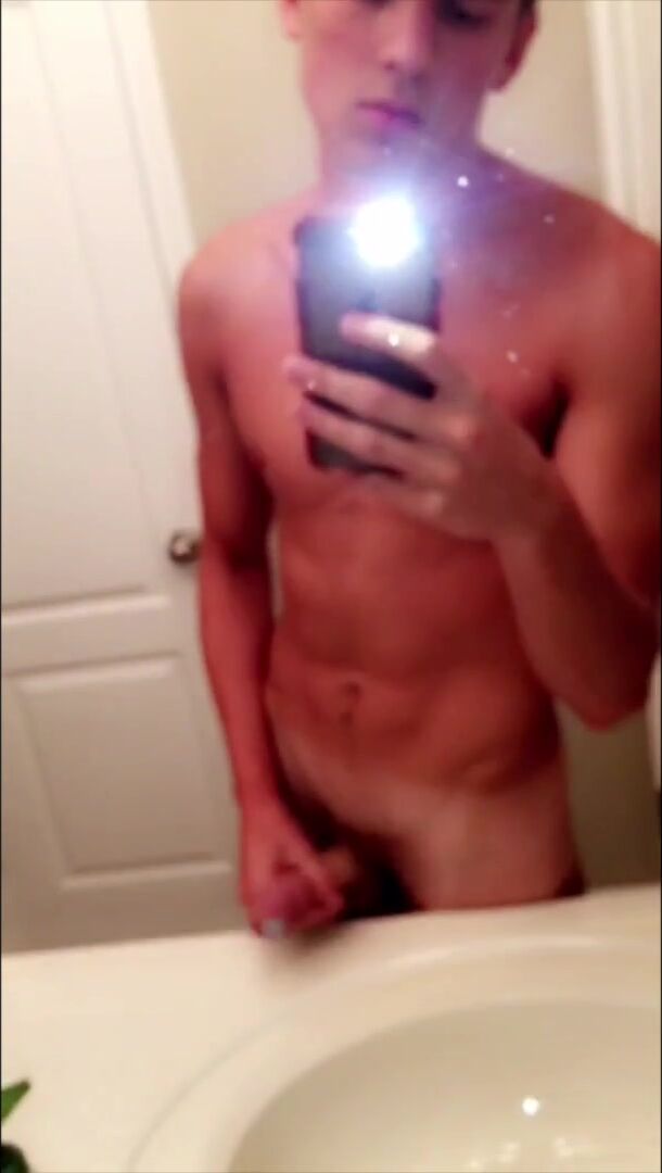 Cute guy strokes cock in bathroom mirror