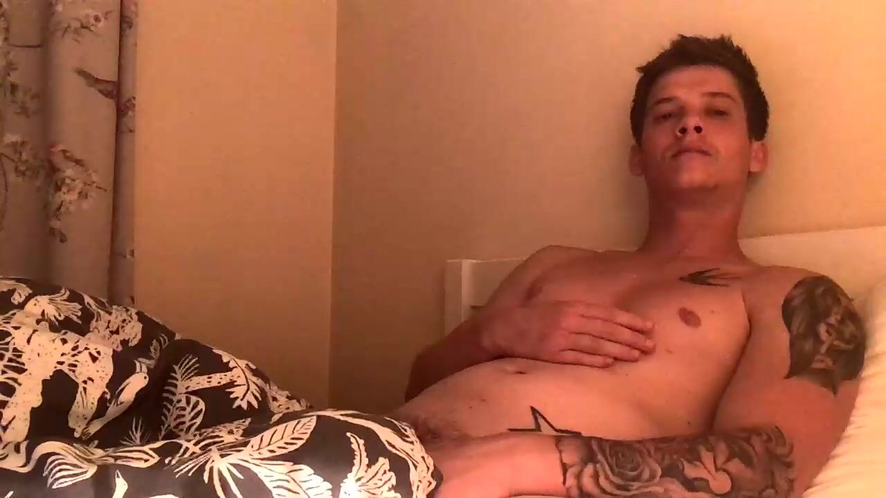 Tattooed guy relaxing on bed - gay porn action