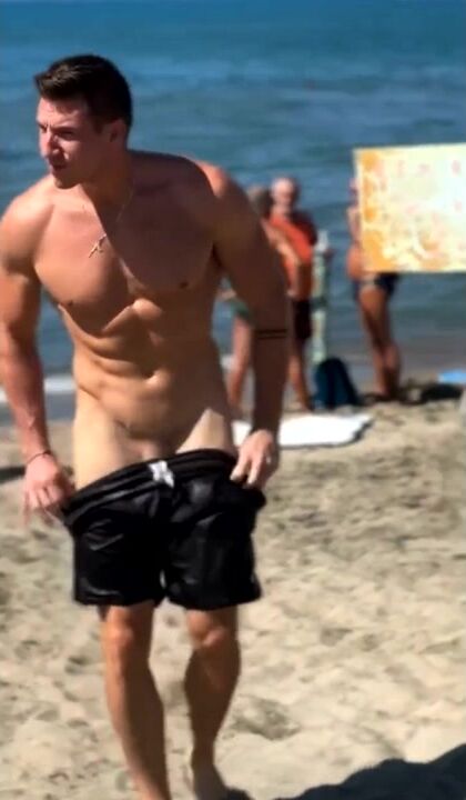 Man takes off swimming trunks on a beach