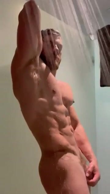 Chico musculoso posa en la ducha