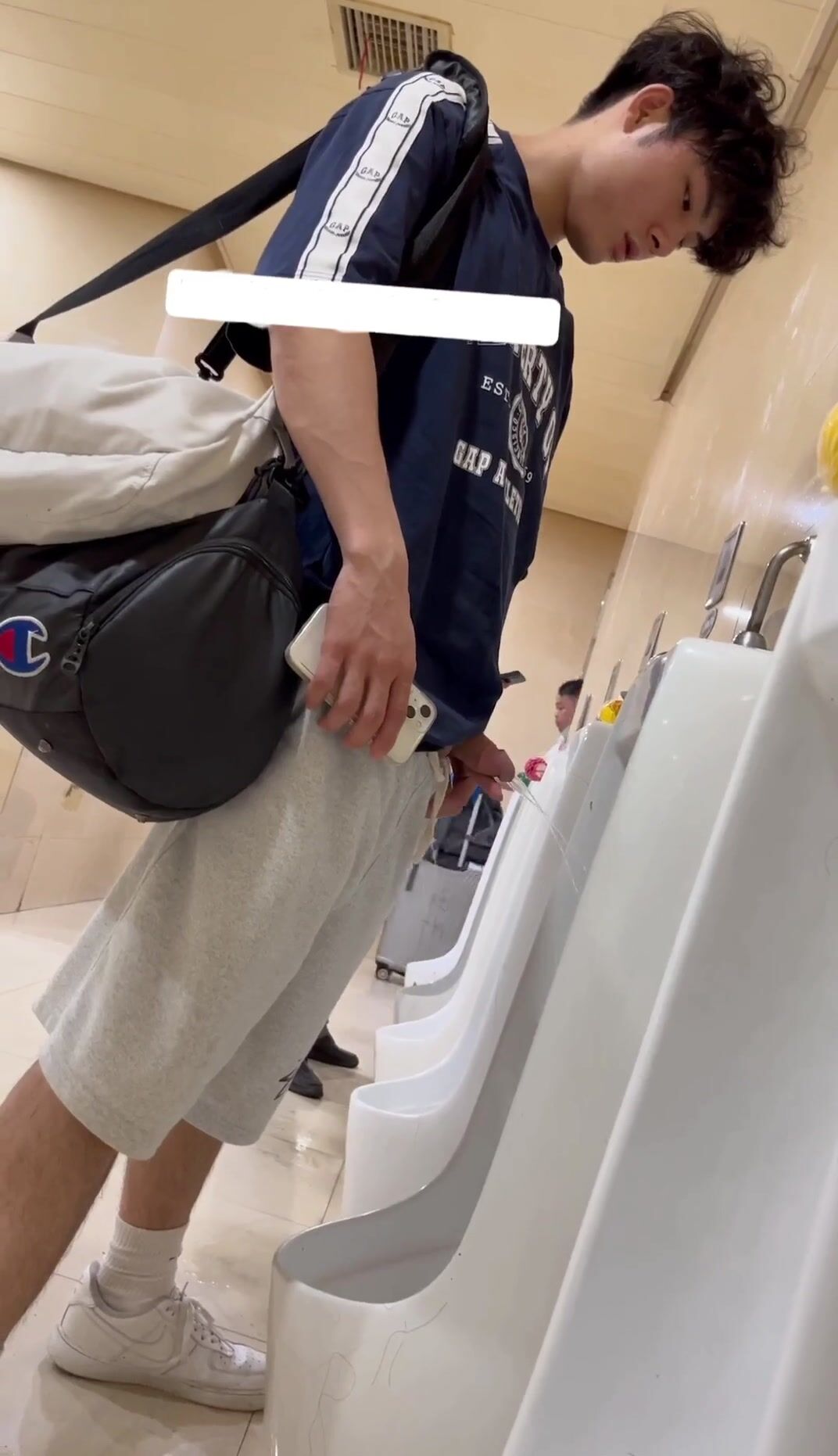 Jeune asiatique circoncis pisse à l'urinoir