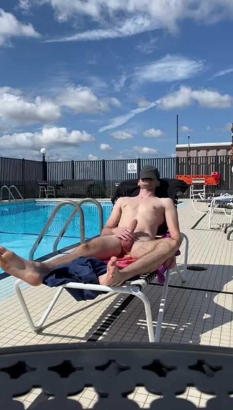 Twink strokes cock on poolside sunlounger