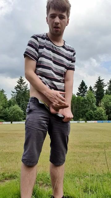 Twink strokes uncut cock and cums on field