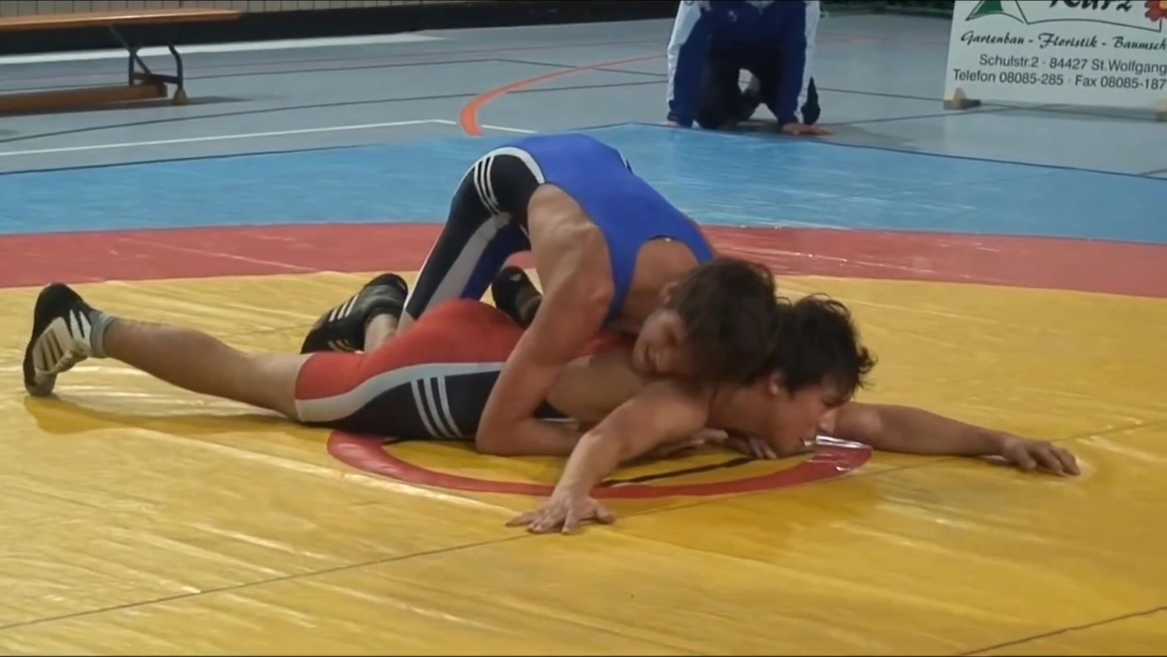 Two handsome boys wrestling in tight swimsuits