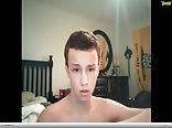 Cute young boy gets naked on his bed